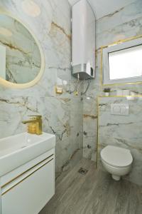 a bathroom with a toilet and a sink and a mirror at Luxury Apartment Veronika in Hvar