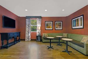 a waiting room with a couch and tables and a tv at Hampton Inn & Suites Pigeon Forge On The Parkway in Pigeon Forge