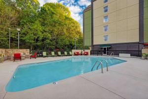 a pool with chairs and tables and a building at Hampton Inn & Suites Pigeon Forge On The Parkway in Pigeon Forge