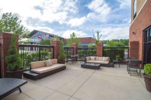 un patio con 2 sofás, mesas y sillas en Hampton Inn Greenville en Greenville