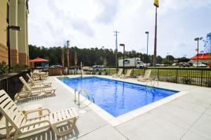 a pool with chaise lounge chairs and a hotel at Hampton Inn Moss Point in Moss Point