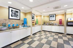 a room with white cabinets and a checkered floor at Hampton Inn Moss Point in Moss Point