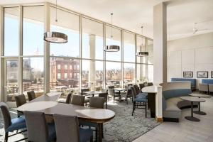 um restaurante com mesas e cadeiras e janelas grandes em Homewood Suites University City Philadelphia em Filadélfia