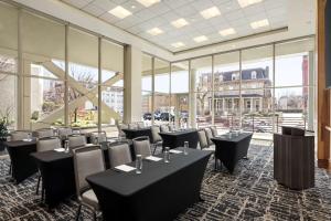 ein Restaurant mit Tischen und Stühlen in einem Zimmer mit Fenstern in der Unterkunft Homewood Suites University City Philadelphia in Philadelphia