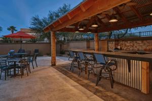 a patio with tables and chairs and a bar at DoubleTree by Hilton Phoenix-Gilbert in Gilbert