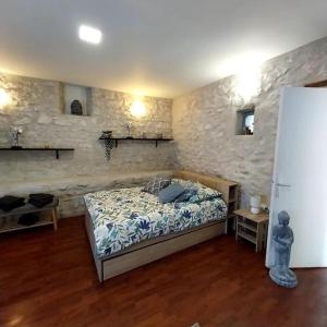 a bedroom with a bed and a stone wall at Gite "D" dans une ancienne corps de ferme in Poigny +20 photos