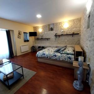 a bedroom with a bed and a stone wall at Ancien corps de ferme in Poigny