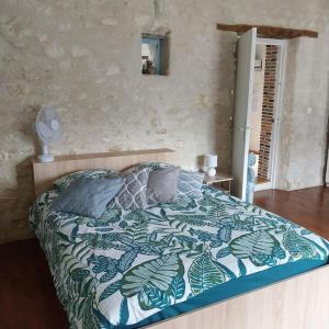 a bedroom with a bed with a blue and white comforter at Gite dans une ancienne corps de ferme D in Provins