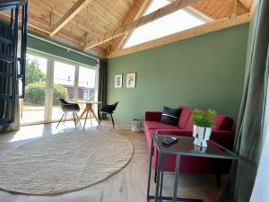 a living room with a red couch and a table at DünenMeer Ferienwohnung in Kühlungsborn