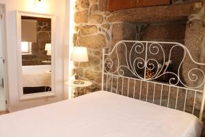 a bedroom with a bed and a stone wall at Quinta da Mó in Terras de Bouro +99 photos