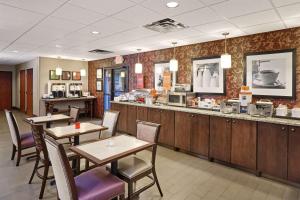 a restaurant with tables and chairs and a counter at Hampton Inn East Peoria in Peoria