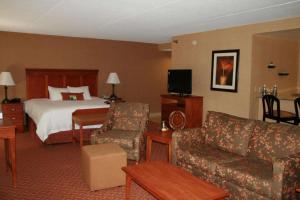 a hotel room with a bed and a couch at Hampton Inn East Peoria in Peoria