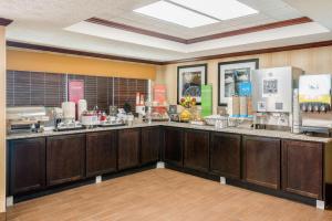 a kitchen with wooden cabinets and a counter top at Hampton Inn Parkersburg/Mineral Wells in Mineralwells