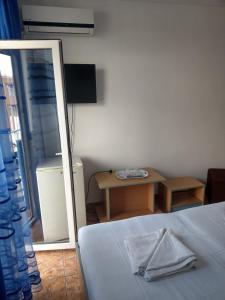 1 dormitorio con cama, espejo y mesa en Hotel Vila Alex, en Costinesti