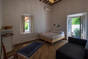 a bedroom with a bed and a couch and windows at La casa del Geologo in Stromboli