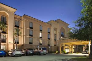 duży budynek z samochodami zaparkowanymi przed nim w obiekcie Hampton Inn & Suites Pensacola/Gulf Breeze w mieście Gulf Breeze