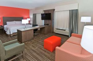 Hampton Inn & Suites Pensacola/I-10 Pine Forest Road في بينساكولا: غرفة في الفندق مع سرير ومكتب