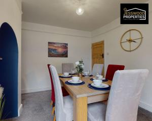 a dining room with a wooden table and chairs at Stylish 3 Bedroom House by Jesswood Properties Short Lets near M1 Luton Airport For Contractors & Business in Luton