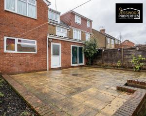 a patio in front of a brick house at Stylish 3 Bedroom House by Jesswood Properties Short Lets near M1 Luton Airport For Contractors & Business in Luton