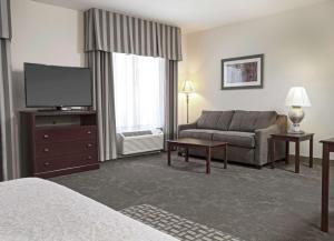 um quarto de hotel com um sofá e uma televisão em Hampton Inn & Suites Prescott Valley em Prescott Valley