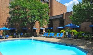 una piscina con sillas y sombrillas azules en Hampton Inn Parsippany, en Parsippany