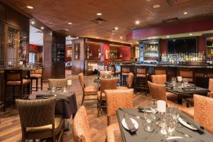 a restaurant with tables and chairs and a bar at Hampton Inn Parsippany in Parsippany