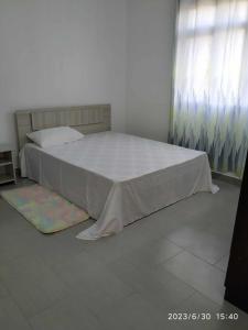 a bedroom with a bed with a white bedspread at A 7 Villa in Quartier Militaire