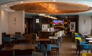 ein Restaurant mit Tischen und Stühlen und eine Bar in der Unterkunft Hampton Inn Perry in Perry