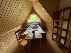 Habitación con cama y mesa en el ático en Pokoje Goscinne u Naglaka Willa Zab en Ząb