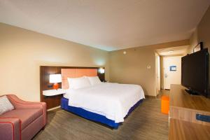 Hampton Inn Pennsville في Pennsville: غرفة فندق بسرير وتلفزيون