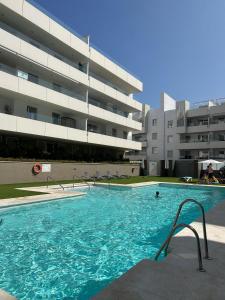 une grande piscine en face d'un bâtiment dans l'établissement Maribel Apartamento Moderno, à Marbella