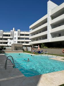 une personne dans une piscine à côté d'un bâtiment dans l'établissement Maribel Apartamento Moderno, à Marbella