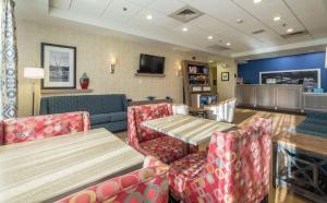 - un restaurant avec une table, des chaises et un canapé dans l'établissement Hampton Inn Freeport/Brunswick, à Freeport