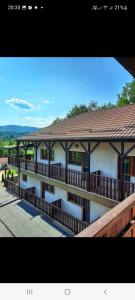 a building with a balcony with a roof at Pensiunea Arido in Cornu de Jos