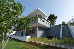 a house with an orange tree in front of it at Iphigenia Luxury Flat in Sarandë