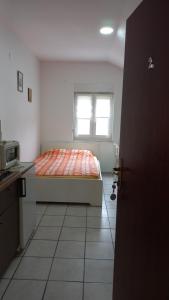 Schlafzimmer mit einem Bett und einem Fenster in der Unterkunft Apartments Popov in Crikvenica