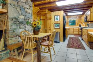 a kitchen with a table and chairs and a stone wall at Secluded Rustic Cabin Next to South Toe River! in Busick