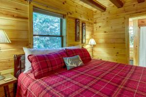 a bedroom with a bed in a log cabin at Secluded Rustic Cabin Next to South Toe River! in Busick