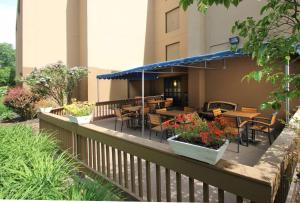 a balcony with tables and chairs on a building at Hampton Inn Portland-Airport in South Portland