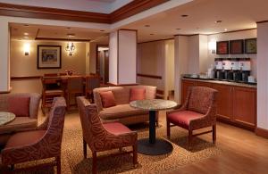 a hotel lobby with a table and chairs and a kitchen at Hampton Inn Portland-Airport in South Portland