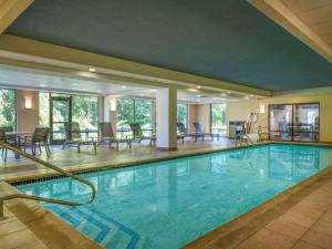 a pool in a hotel with chairs and tables at Hampton Inn Raynham-Taunton in Raynham