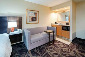 Cette chambre d'hôtel dispose d'un canapé et d'un lavabo. dans l'établissement Hampton Inn & Suites Bremerton, à Bremerton