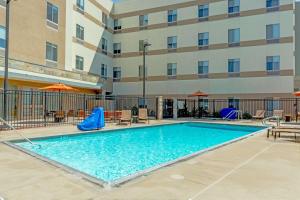 a pool at a hotel with tables and chairs at Hampton Inn & Suites Riverside/Corona East in Riverside