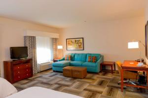 sala de estar con sofá azul y TV en Hampton Inn & Suites Riverside/Corona East en Riverside