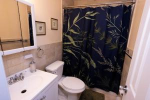 y baño con aseo y cortina de ducha. en Family 3-bedroom home (2nd floor near EWR/Outlet), en Elizabeth