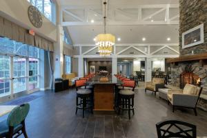 a lobby of a hotel with a bar and chairs at Hampton Inn & Suites Raleigh/Cary I-40 (PNC Arena) in Cary