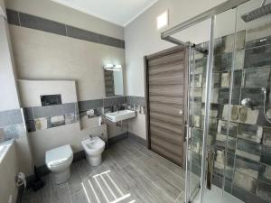 a bathroom with a toilet and a sink and a shower at APPARTAMENTO ELEGANTE CARBONIA in Carbonia +16 photos