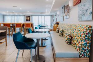 a restaurant with a couch and tables and chairs at Hampton Inn Rehoboth Beach in Rehoboth Beach