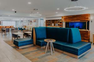 - un salon avec un canapé bleu et une table dans l'établissement Hampton Inn Rehoboth Beach, à Rehoboth Beach