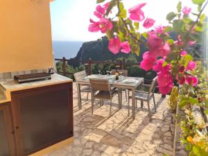 a table and chairs on a patio with pink flowers at Un Tuffo nel Blu in Sperlonga